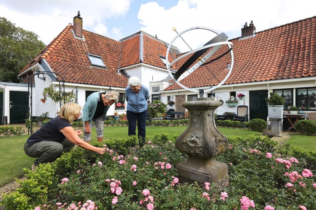 Binnentuin van het hofje van Paling en Van Foreest met 3 hofdames.