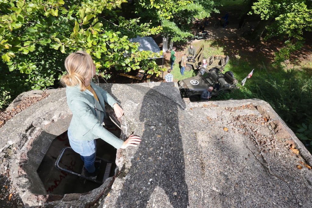 Bunker Alkmaardenhout, vrouw kijkt door het gat bovenin de bunker naar beneden.