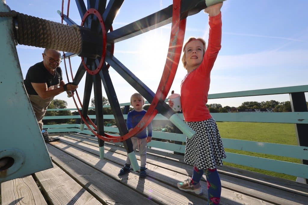 Molen, twee kindje draaien het rad.