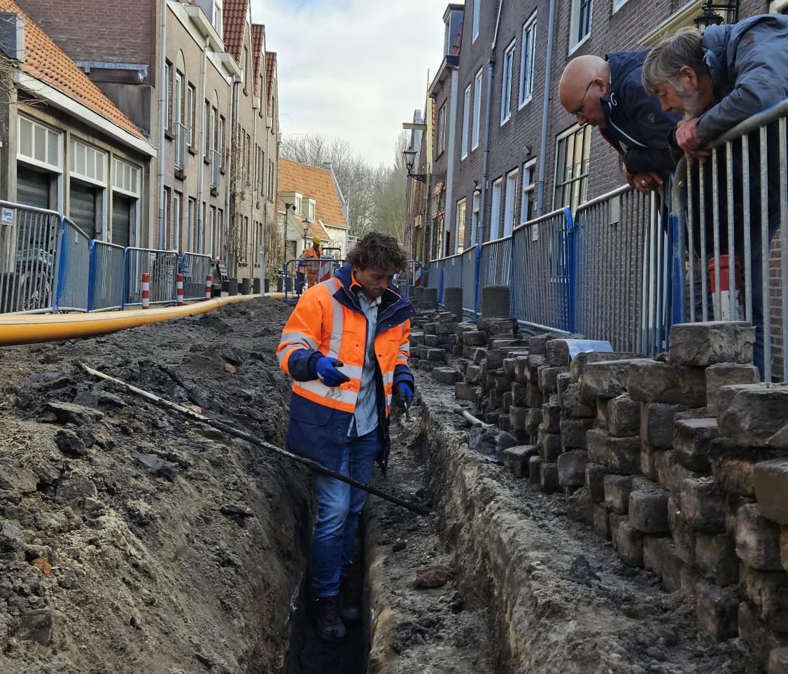 Archeoloog Niels Tuinman in een smalle sleuf in de Torenburg. Dit is het straatje in het verlengde van de Dijk in het centrum van Alkmaar.